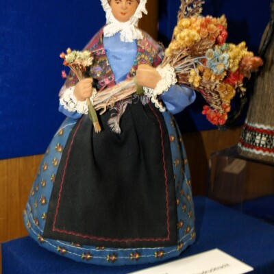 Provence: Blumenverkäuferin in traditioneller Blaudrucktracht